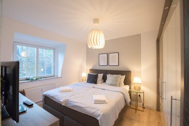 Schlafzimmer mit Bett, Schrank, Fernseher